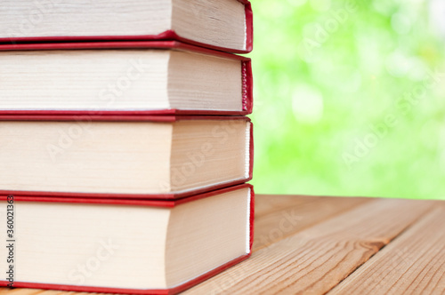 stack of books on the wood table in the nature with bokeh lights