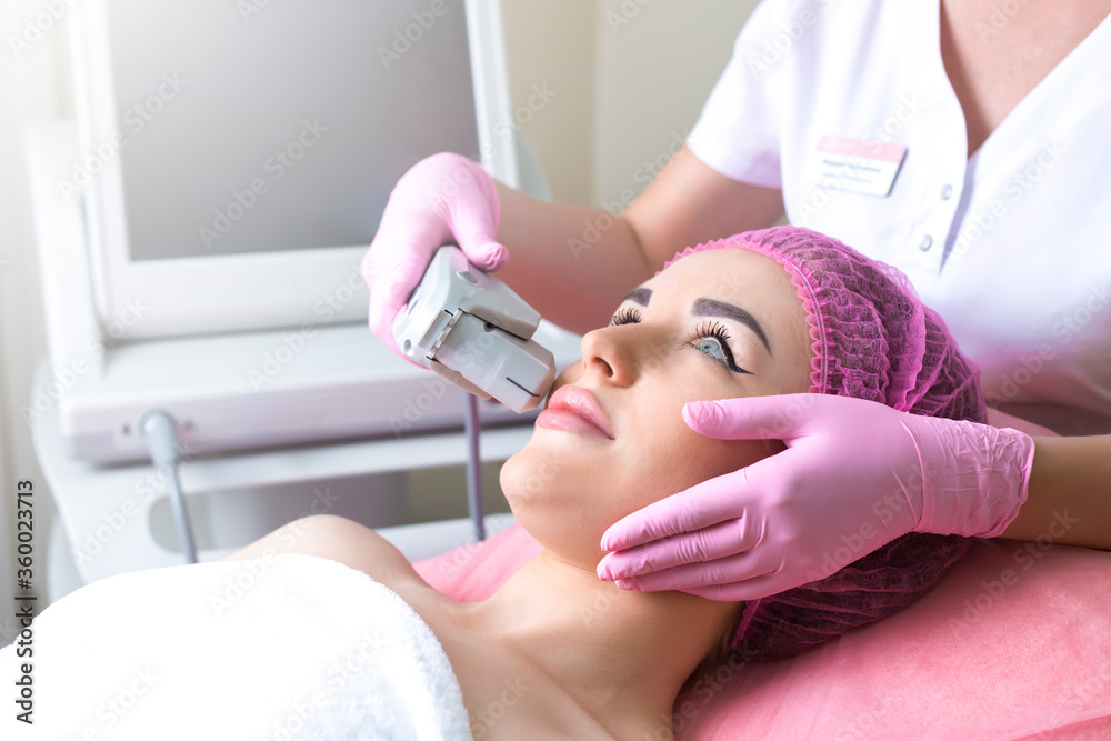 Ultrasonic face lifting of a young beautiful woman. Pulling the skin. Ultrasonic face lifting of a young beautiful woman. Pulling the skin.