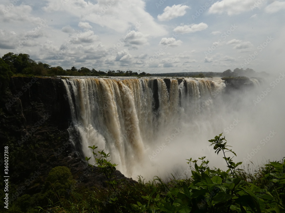 Scenic view of waterfall under cloudy sky, Victoria Falls, Zimbabwe