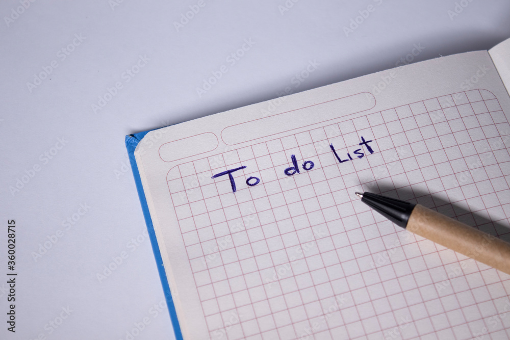 blue notebook with a pen on it and a sign 'To do list' on it - handwritten. stationery concept. copy space. isolated. High quality photo blue notebook with a pen on it and a sign 'To do list' on it - handwritten. stationery concept. copy space. isolated. High quality photo