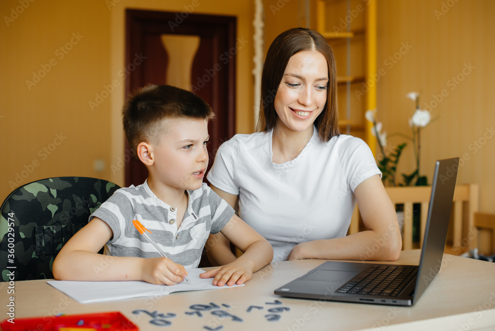 A mother and her child are engaged in distance learning at home in front of the computer. Stay at home, training A mother and her child are engaged in distance learning at home in front of the computer. Stay at home, training