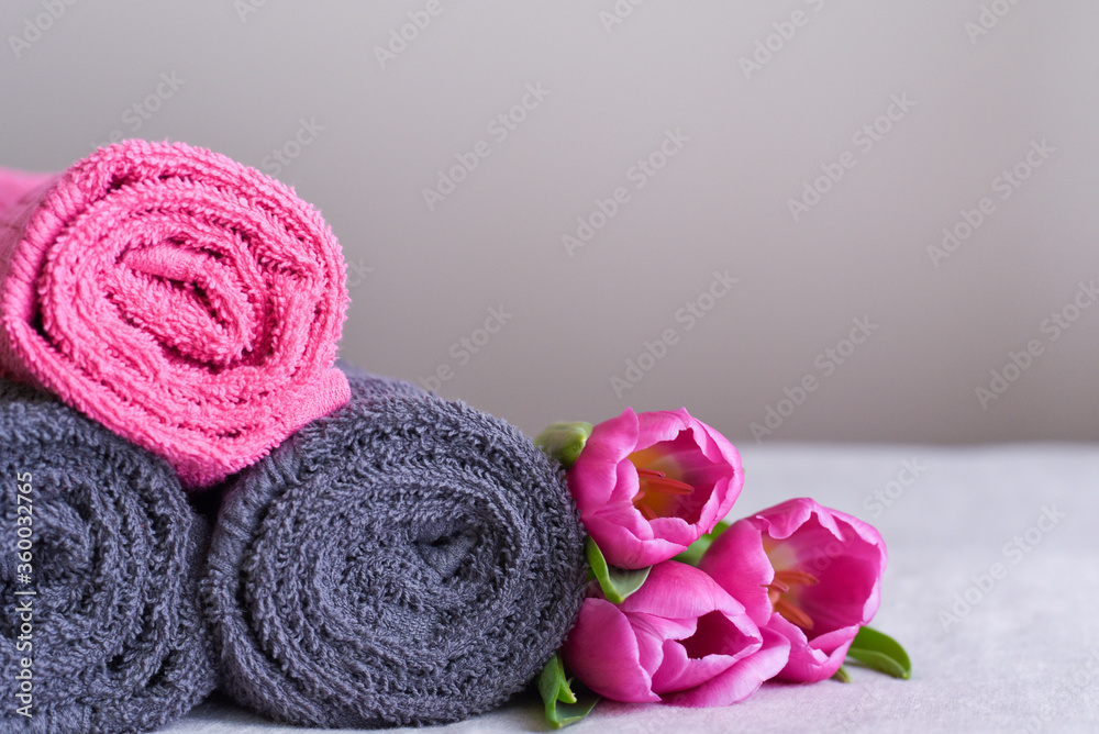 a stack of towels in rolls with a pink tulips a stack of towels in rolls with a pink tulips