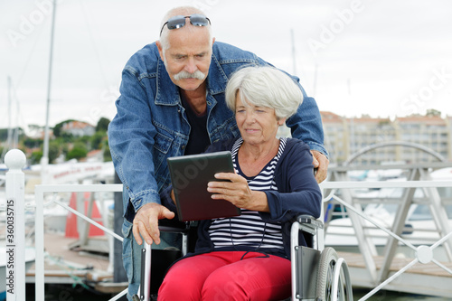 senior couple looking at tablet woman in wheelchair