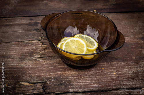 A plate with slices of lemon on a wooden table