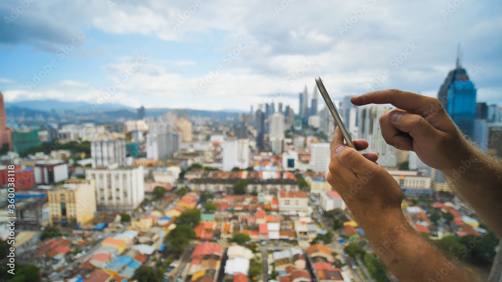 Αυτοκόλλητο The guy is working with a smartphone on a blurred background