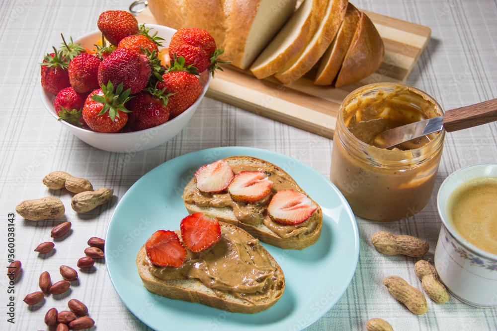 Breakfast with coffee and sandwiches with peanut paste and strawberries