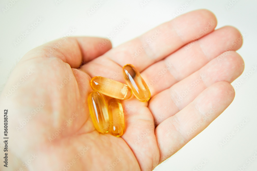 Yellow capsules of vitamin omega 3 in your hand. Biologically active additive. Fish oil in tablets. Medical support and treatment. Yellow capsules of vitamin omega 3 in your hand. Biologically active additive. Fish oil in tablets. Medical support and treatment.