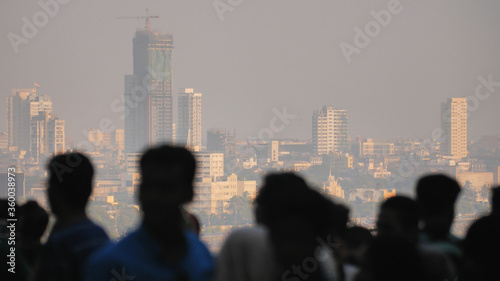 Silhouette of people in Mumbai on the background of the city skyscrapers.