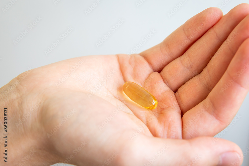 Yellow capsules of vitamin omega 3 in your hand. Biologically active additive. Fish oil in tablets. Medical support and treatment. Yellow capsules of vitamin omega 3 in your hand. Biologically active additive. Fish oil in tablets. Medical support and treatment.