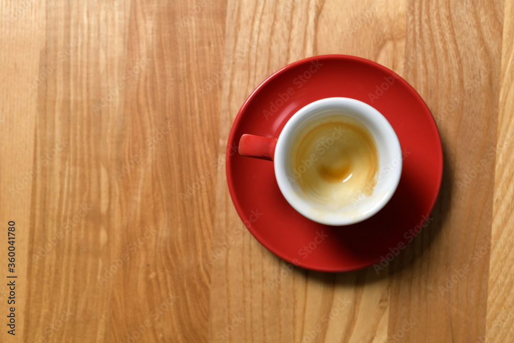 Obraz premium Red cup on a wooden table from which drank coffee