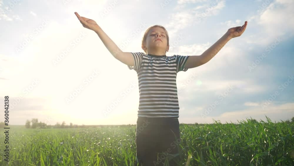 boy prays pulls hands to the sky against a blue sky. child concept faith religion and happy family. kid son hands to the side against lifestyle the blue sky jew praying to god. worship and gratitude boy prays pulls hands to the sky against a blue sky. child concept faith religion and happy family. kid son hands to the side against lifestyle the blue sky jew praying to god. worship and gratitude