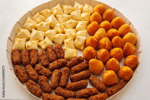 Brazilian traditional snacks, coxinha, quibe e esfiha. Finger food for celebrations. Deep fried and baked savory meal.