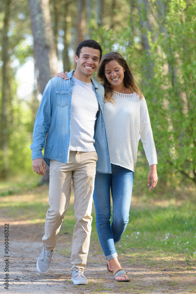 happy couple walking in summer park