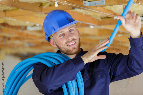 portrait of young builder holding reel of polyurethane cable