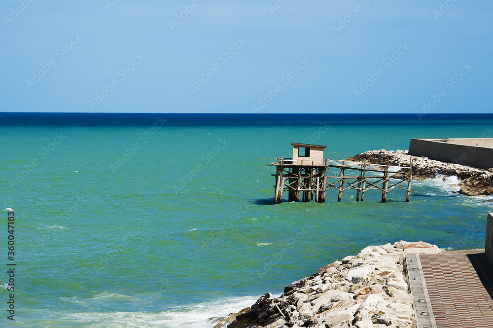 A traditional fishing machine of the city of Termoli, known as ancient Trabucco,very famous and visited by tourists, located on the Gargano Coast, Apulia's national park in Italy. Seascape