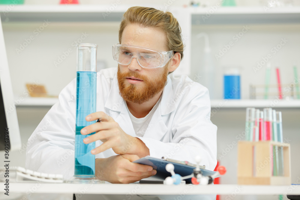 laboratory pipette with drop of liquid over glass test tubes laboratory pipette with drop of liquid over glass test tubes