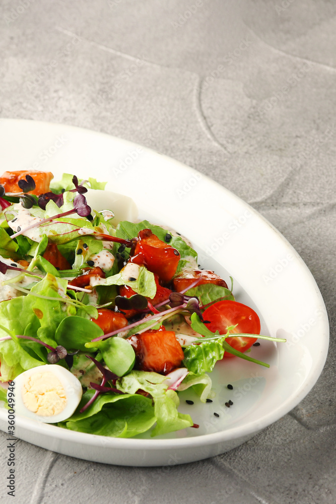 vegetarian caesar with cherry and bell pepper in white plate on concrete background vegetarian caesar with cherry and bell pepper in white plate on concrete background