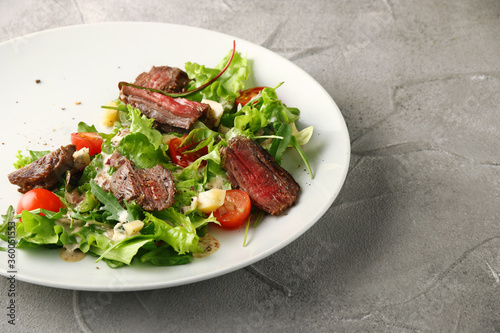 steak salad with leaf of salad fresh cherry tomatoes parmesan cheese and summer sauce closeup