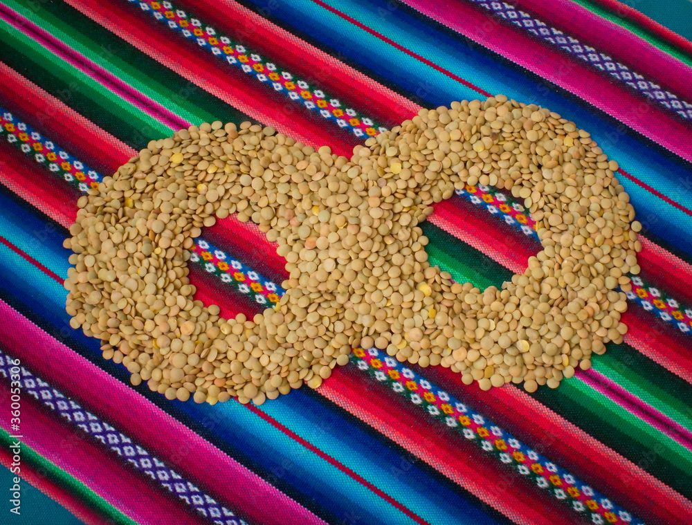 Lentils (Lens culinaris) Form an Infinity Sign , on a Table with a Bolivian Aguayo of Various Colors