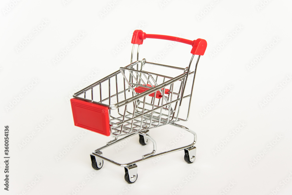 empty miniature red trolley for shopping at an angle on a white background empty miniature red trolley for shopping at an angle on a white background