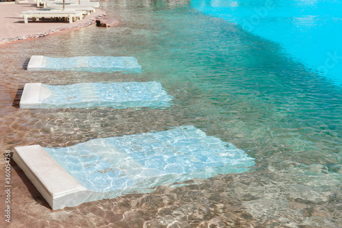 Swimming pool with underwater beds for resting. underwater pool bed