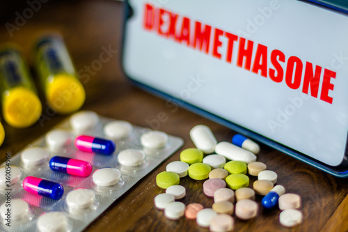 In this photo illustration pharmaceutical pills are seen displayed on a table with a Dexamethasone inscription on the background. Medically corticoid is used to treat COVID-19 (coronavirus). photo