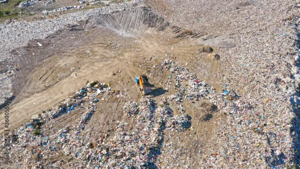 Garbage trucks unload garbage in a city landfill. Aerial view. Earth pollution and environmental disaster concept Garbage trucks unload garbage in a city landfill. Aerial view. Earth pollution and environmental disaster concept