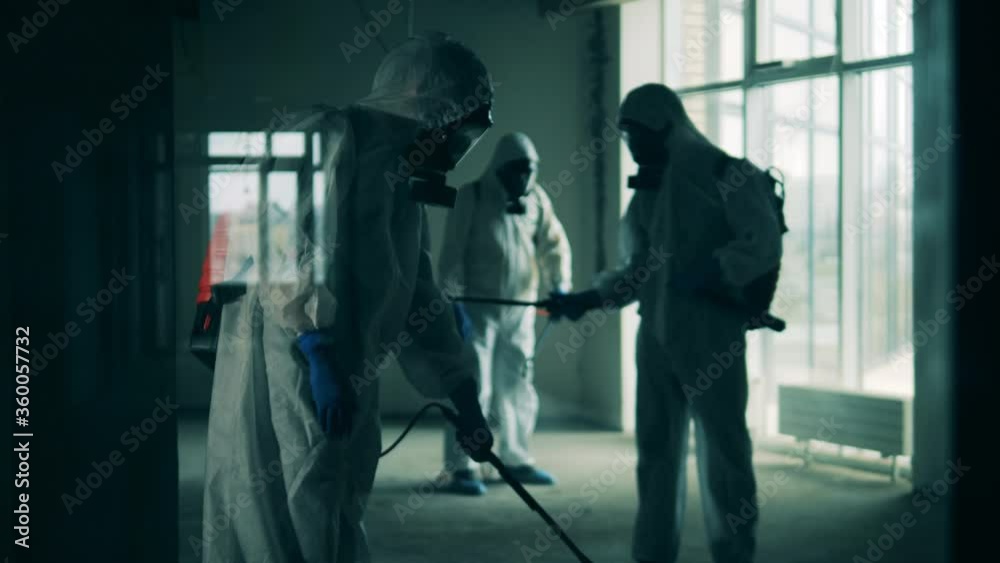 People in hazmats sanitize room during pandemic. People in hazmats sanitize room during pandemic.