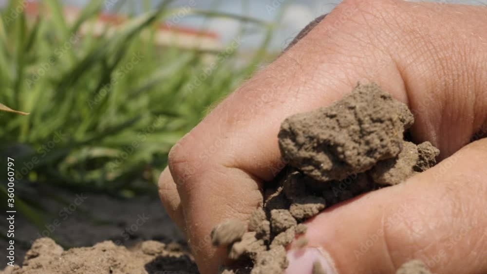 Natural Organic Soil Agriculture. Man Farmer Hands Touching Ground on Field. Close up. Farmer Hands Holding and Pouring Back Organic Soil. Slow Motion. Macro shooting. Natural Organic Soil Agriculture. Man Farmer Hands Touching Ground on Field. Close up. Farmer Hands Holding and Pouring Back Organic Soil. Slow Motion. Macro shooting.