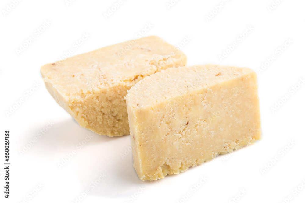 Piece of cheddar cheese isolated on white background. Side view.