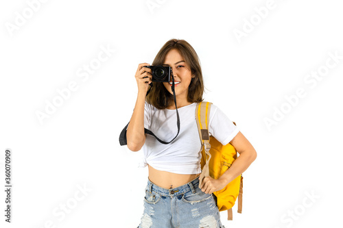 Asian woman tourist holding a camera and carrying a yellow backpack.