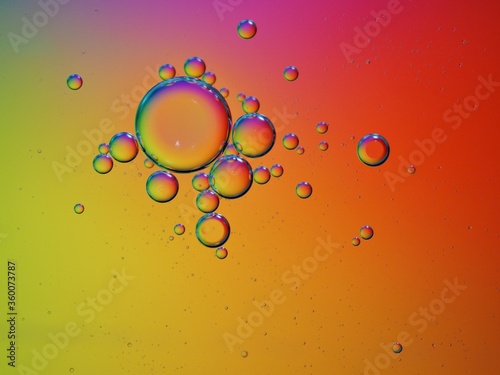 Closeup red yellow oil bubbles with colorful background and blurred droplets ,macro image ,sweet pastel color ,rainbow and colorful balloons background, abstract background
