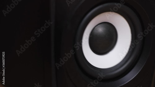 Vibrating bass speaker membrane with white ring. Concept. Close up of moving sub woofer, speaker parts with black membrane spreading sound waves and vibration.