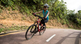 Woman riding bike on sunny mountain trail