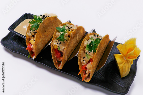 Mexican dish taco,consisting of a small hand-sized corn or wheat tortilla topped with a filling.