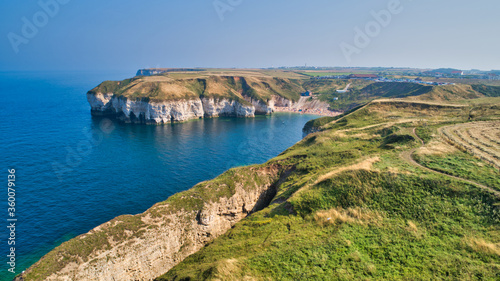 Stunning view of a beautiful secluded coastal bay featuring a large crevice in the foreground