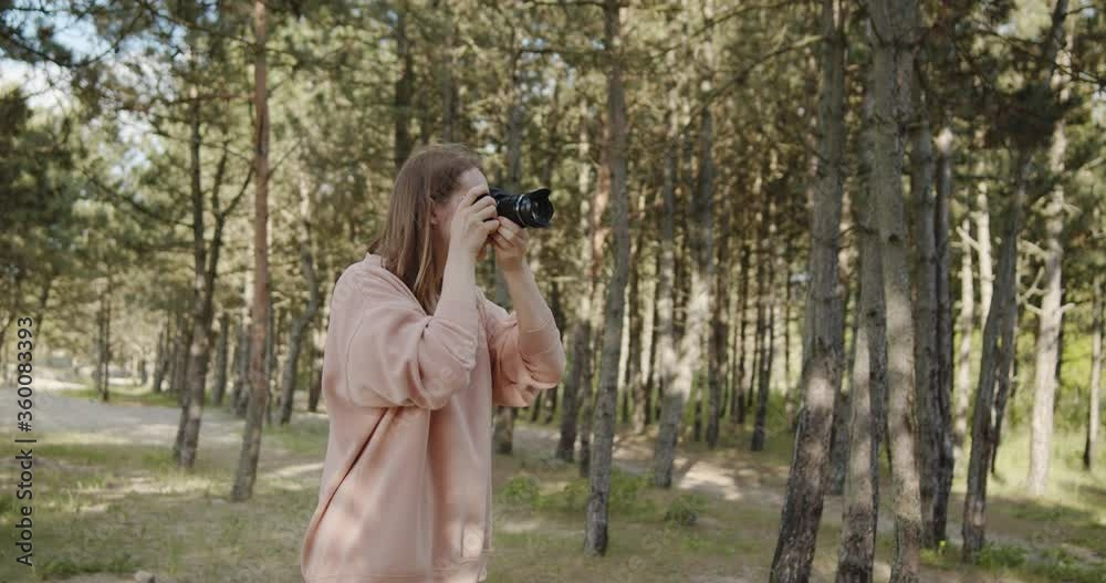 Young woman photographer takes pictures of the forest using digital camera Young woman photographer takes pictures of the forest using digital camera