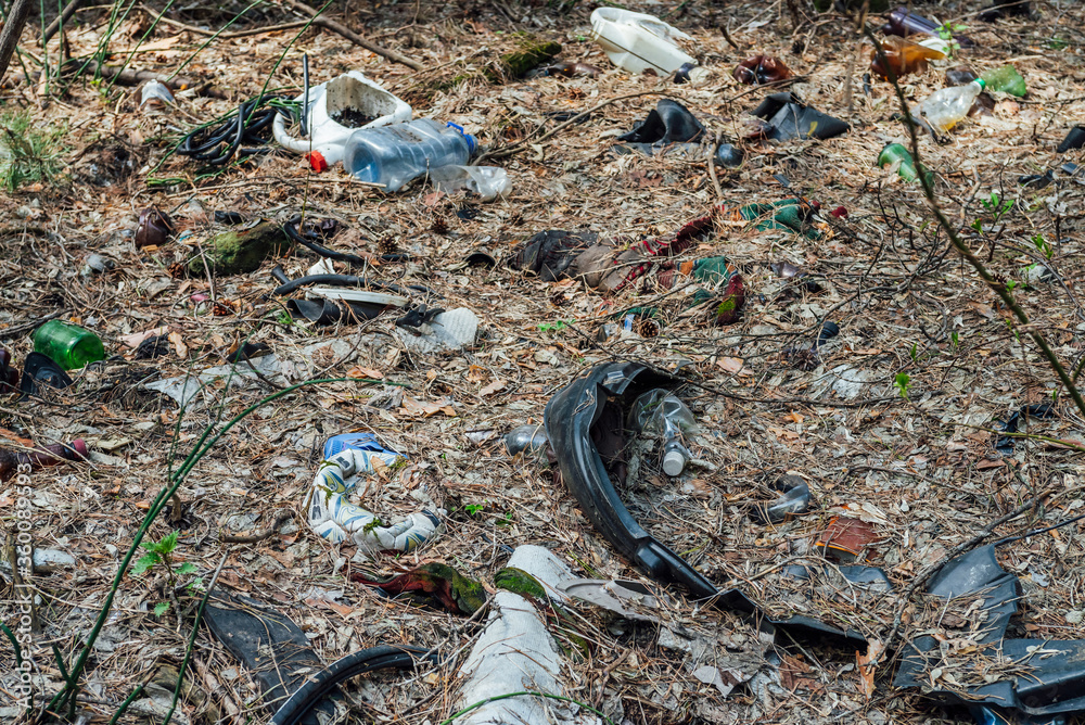 Garbage pile in forest among plants. Toxic plastic into nature everywhere. Rubbish heap in park among vegetation. Contaminated soil. Environmental pollution. Ecological issue. Throw trash anywhere. Garbage pile in forest among plants. Toxic plastic into nature everywhere. Rubbish heap in park among vegetation. Contaminated soil. Environmental pollution. Ecological issue. Throw trash anywhere.