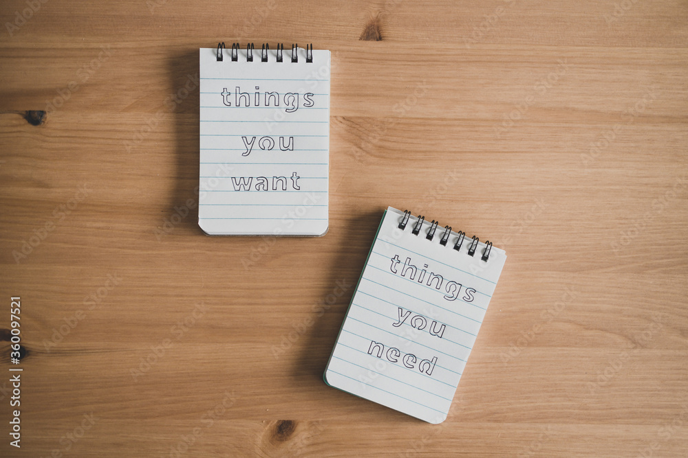 notepads with titles Things you need vs things you want side by side on desk ready for meditation notepads with titles Things you need vs things you want side by side on desk ready for meditation