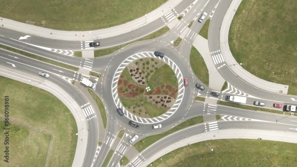 Vertical aerial view of traffic movement at the intersection around the round about. Slow motion. Vertical aerial view of traffic movement at the intersection around the round about. Slow motion.