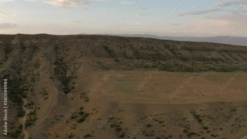 The Scenic View Of Tbilisi District City In Georgia Revealed Behind The Sandy Mountain On A Foggy Day - ascending drone shot