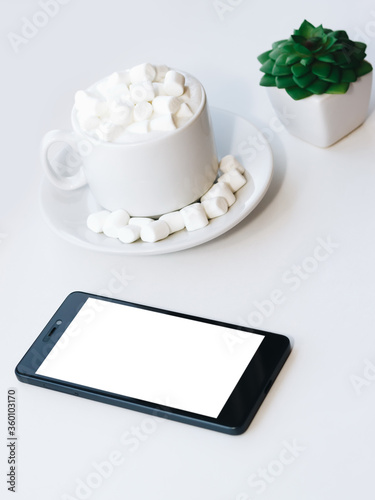 Wallpaper Mural Smartphone lying on white table, cup of cappuccino and green plant Torontodigital.ca