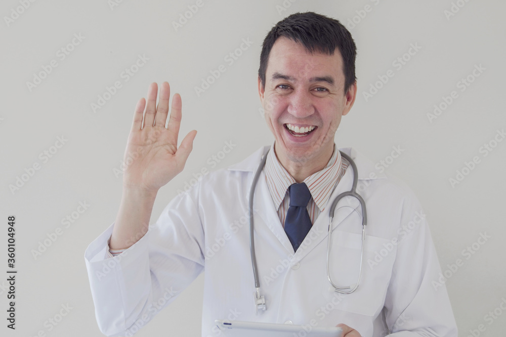 Mixed race Asian medical male online doctor waving his hand and working remotely, telehealth, telemedicine, distance consulting concept Mixed race Asian medical male online doctor waving his hand and working remotely, telehealth, telemedicine, distance consulting concept