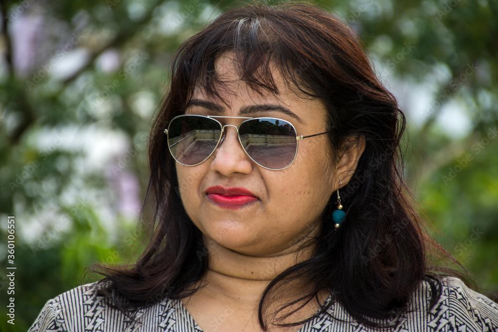 Indian female model wearing western style white t-shirt and sunglasses Indian female model wearing western style white t-shirt and sunglasses