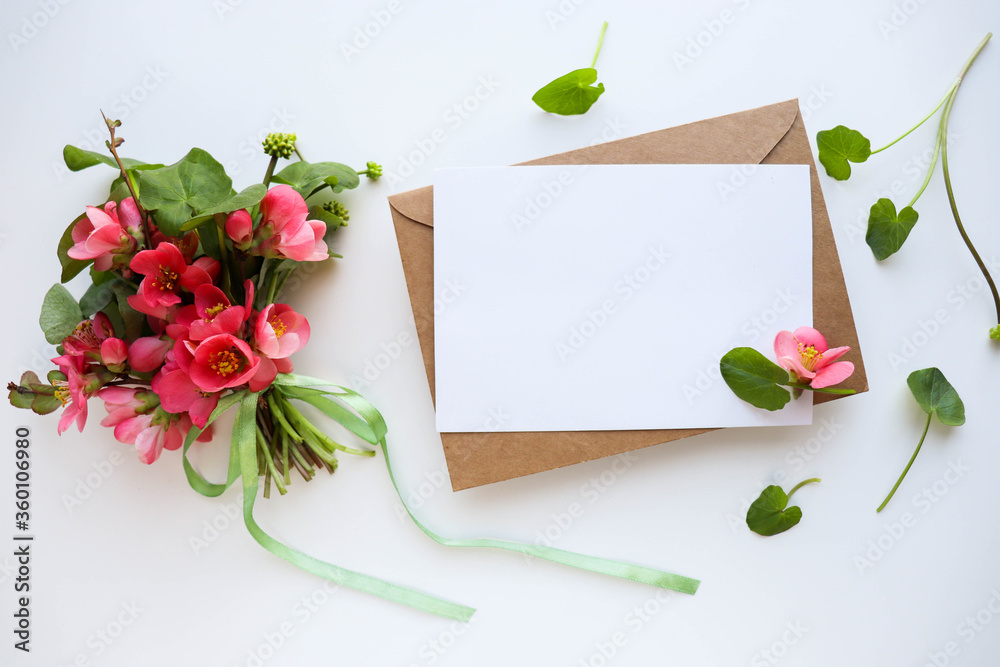 framework for invitation or congratulation. Greeting card mockup with space for text. small bouquet of pink flowers and an envelope on a white background. wedding invitation.