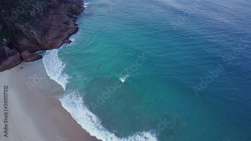 High aerial view of bodyboarders riding the waves at Shoal Bay, Australia, drone photo