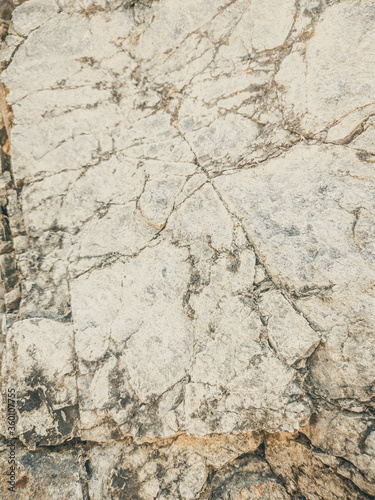 Natural background. Closeup edged shabby cliff cracks. Gray-brown stone rock texture of mountains. Vintage and faded matt style colour in tinted photo. Concept of geolog, mountaineering or hard work photo