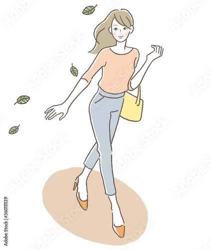 風に舞う葉を見上げ歩く女性　俯瞰