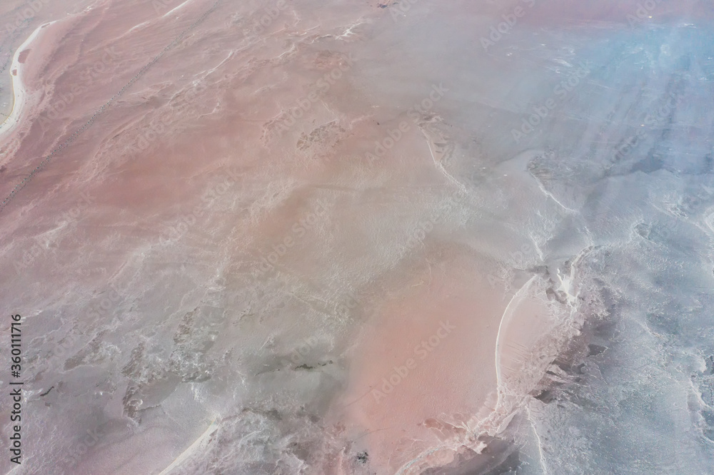 Shooting from air to pink salt lake with amazing patterns on the water