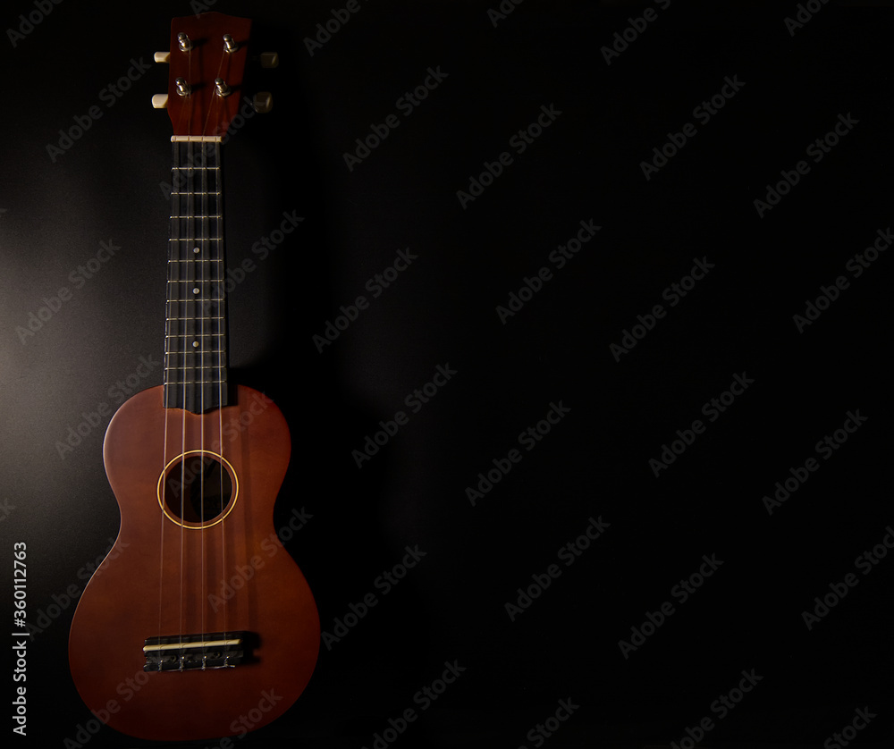 Naklejka premium Beautiful Ukulele on black background